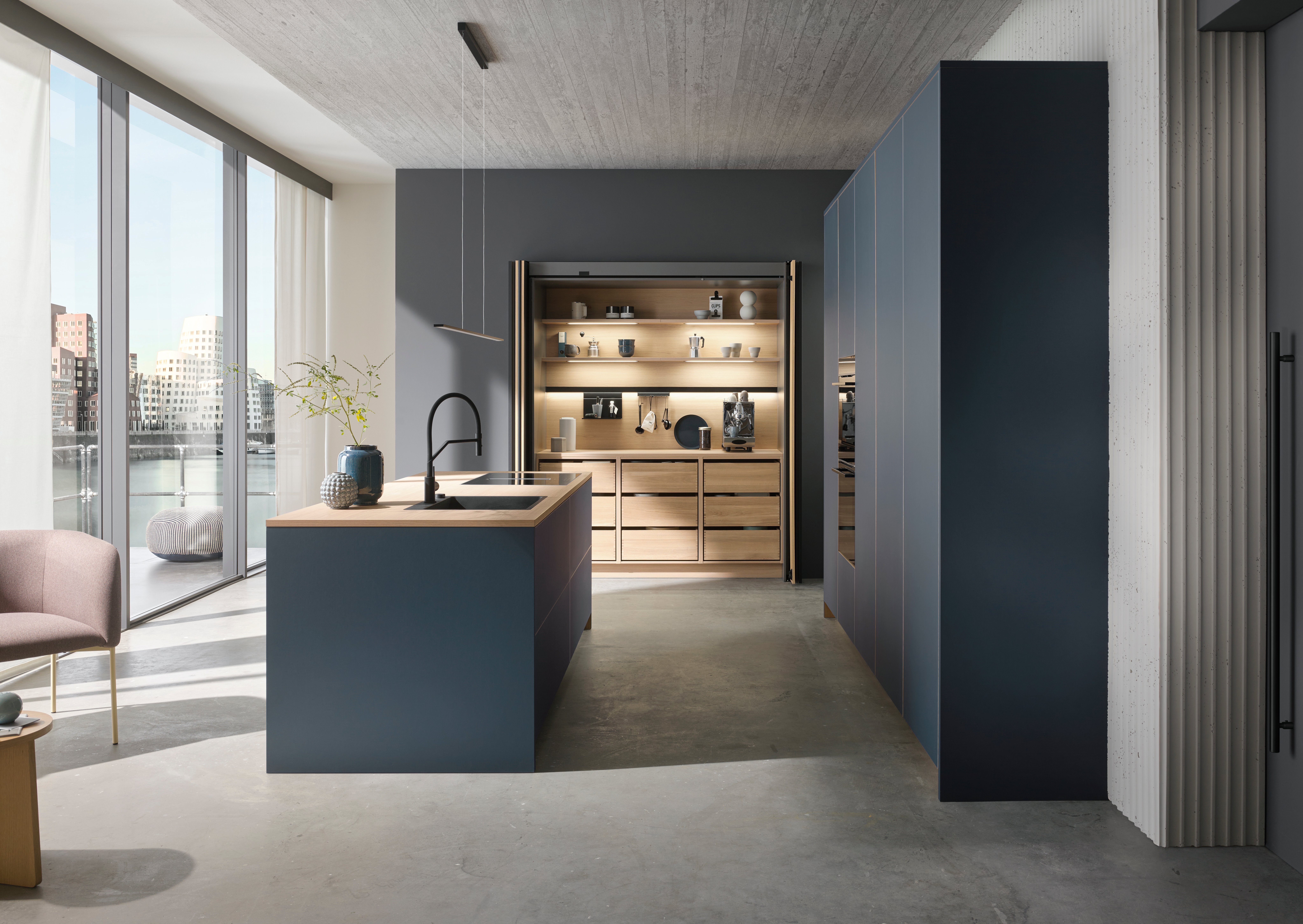 Moderne Küche mit Kochinsel, offenen Regalen und großen Fenstern.